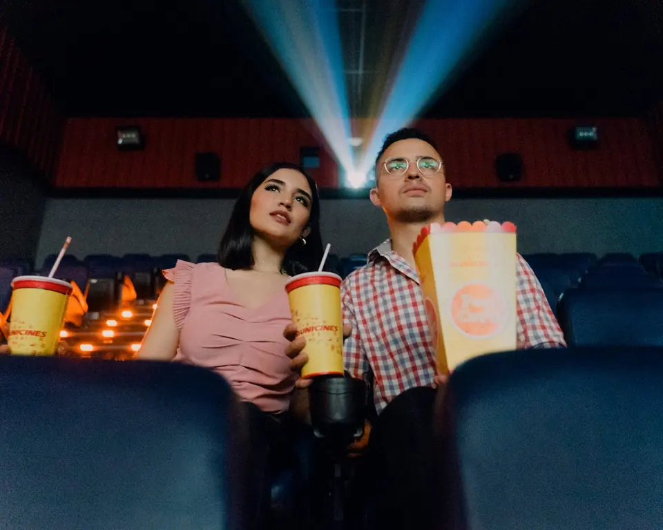 Paar im Kino mit Popcorn und Getränken (Freizeit/Kino)