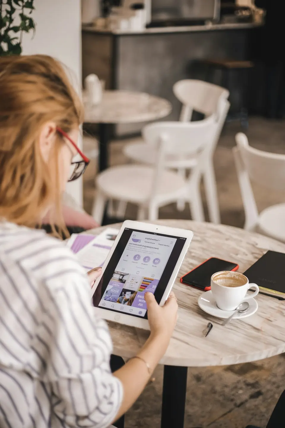 Inhaberin wertet Zahlen am Laptop im Café aus
