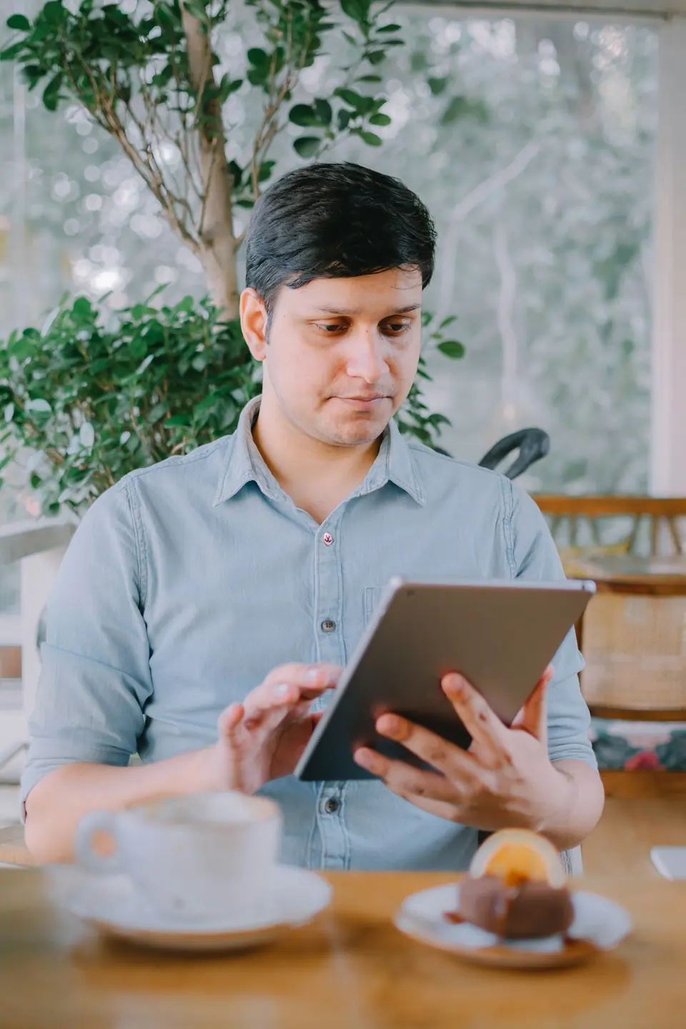Gastronomin prüft den Dienstplan auf dem Tablet an der Bar
